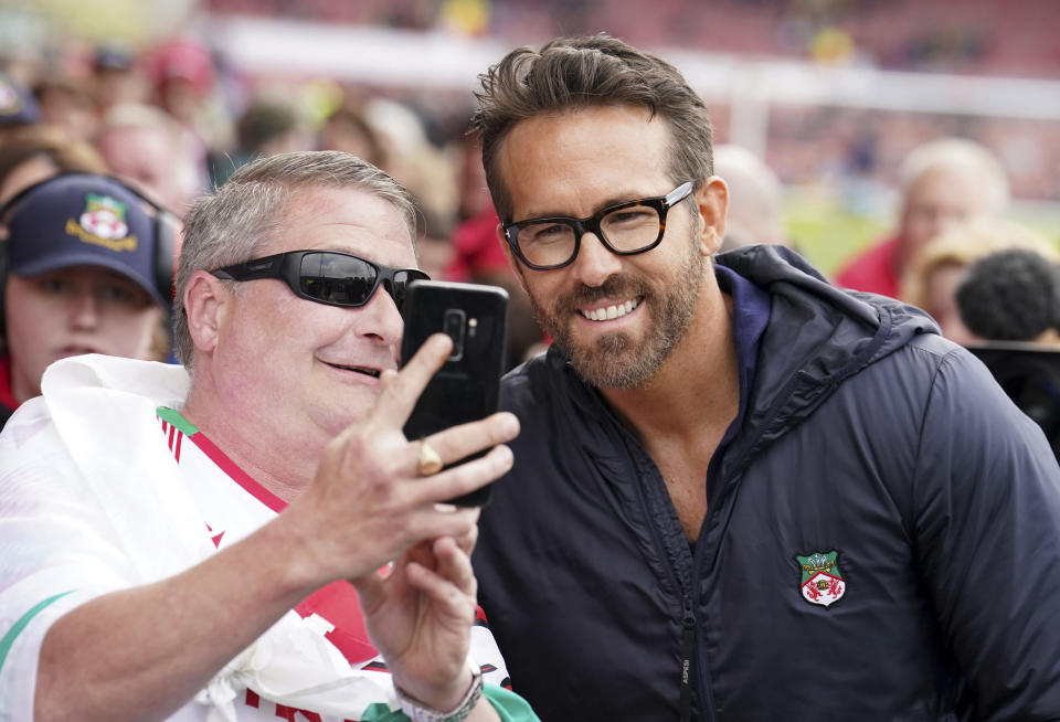 Wrexham co-owner Ryan Reynolds poses with fans ahead of the National League soccer match between Wrexham and Boreham Wood at The Racecourse Ground, in Wrexham, Wales, Saturday April 22, 2023. (Martin Rickett/PA via AP)