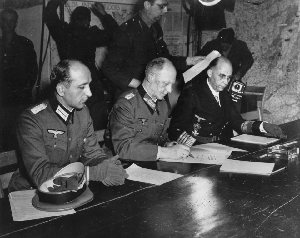 FILE - In this May 7, 1945 file photo, Gen. Alfred Jodl, center, signs the unconditional surrender of all armed German forces imposed by the Allied Powers, at Supreme Commander Eisenhowers headquarters in Reims, France. He is flanked by Gen. Wilhelm Oxenius, Commander of the German Luftwaffe, left, and General Admiral and Commander in Chief of the German fleet, Hans-Georg von Friedeburg, right. Nazi commanders signed their surrender to Allied forces in a French schoolhouse 75 years ago this week, ending World War II in Europe and the Holocaust. (AP Photo/File)