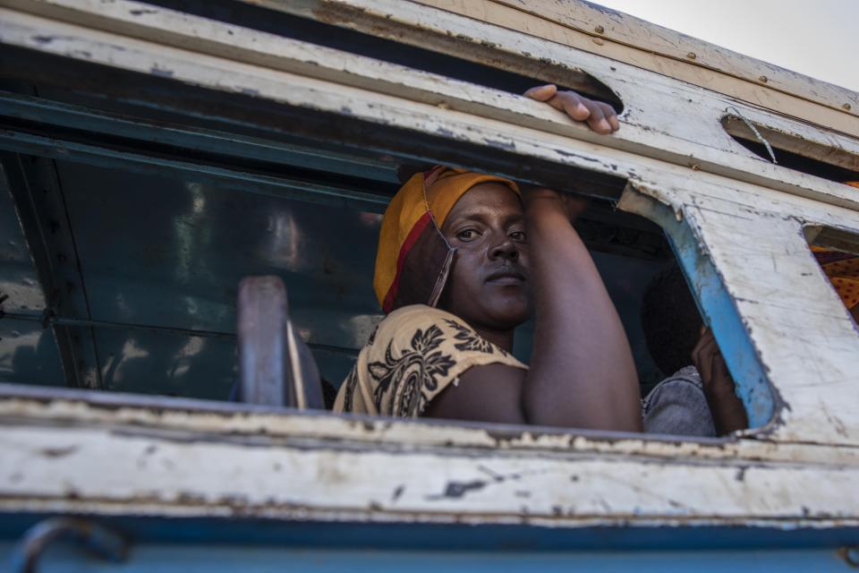 Tigray refugees who fled the conflict in the Ethiopia's Tigray ride a bus going to the Village 8 temporary shelter, near the Sudan-Ethiopia border, in Hamdayet, eastern Sudan, Tuesday, Dec. 1, 2020. (AP Photo/Nariman El-Mofty)