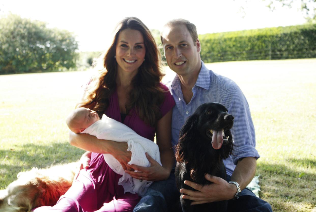 A photo released by Kensington Palace on Aug. 19, 2013, shows Prince William and Duchess Kate with their newborn baby boy, Prince George; Tilly the retriever (left), a Middleton family pet; and Lupo, the couple's cocker spaniel, at the Middleton family home in Bucklebury, Berkshire.