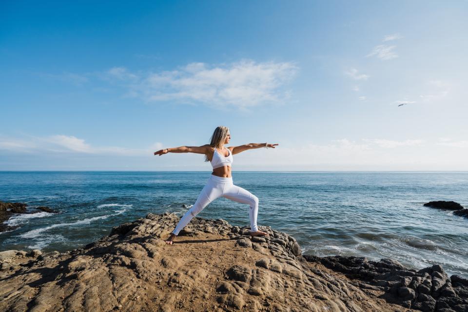 Woman-Working-Out-By-Ocean-Stock-Photo