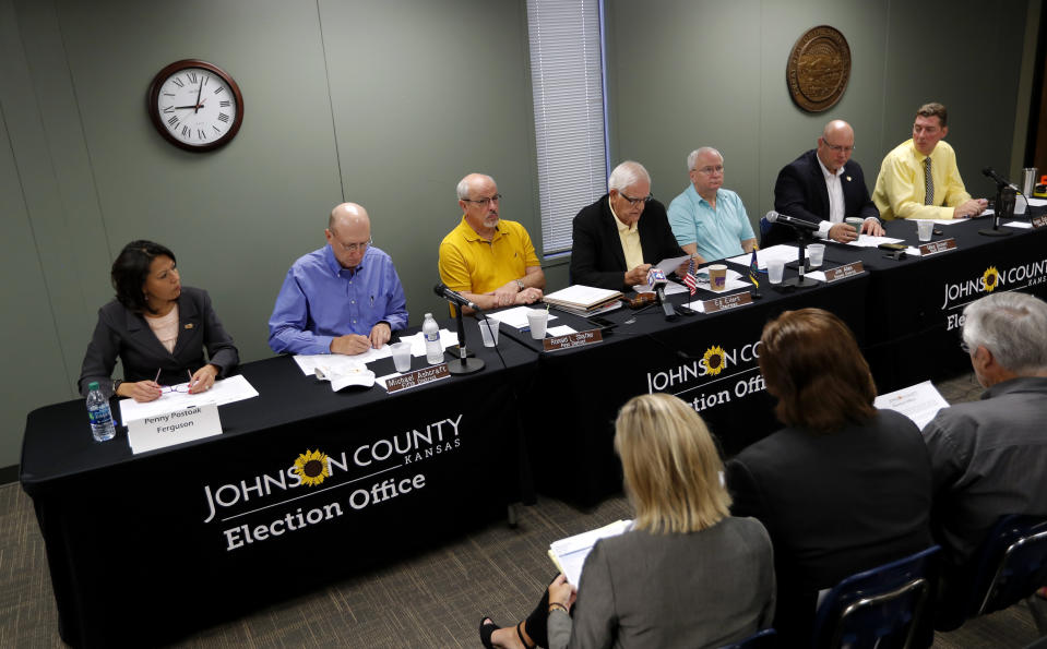 Board of County Commissioners chairman Ed Eilert, center, speaks during the Johnson County Board of Canvassers meeting, Monday, Aug. 13, 2018, in Olathe, Kan. County election officials across Kansas on Monday began deciding which provisional ballots from last week's primary election will count toward the final official vote totals, with possibility that they could create a new leader in the hotly contested Republican race for governor. Secretary of State Kris Kobach led Gov. Jeff Colyer by a mere 110 votes out of more than 313,000 cast as of Friday evening. (AP Photo/Charlie Neibergall)