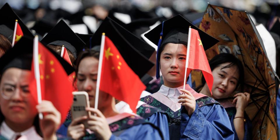 Studierende der Universität Wuhan halten Fahnen während der Abschlussfeier im Stadion der Hochschule am 20. Juni 2023 in Wuhan. - Copyright: Ren Yong/SOPA Images/LightRocket/Getty Images