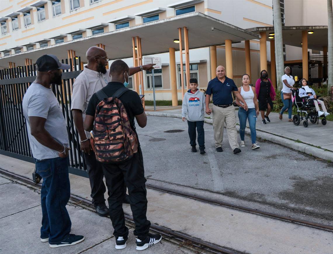 Buses and parents drop off students for the first day at Miami Carol Senior High School in Miami Gardens on Wednesday morning. Security guard Tony starts partially closing the gate before 7:20 a.m. when the final bell rings.