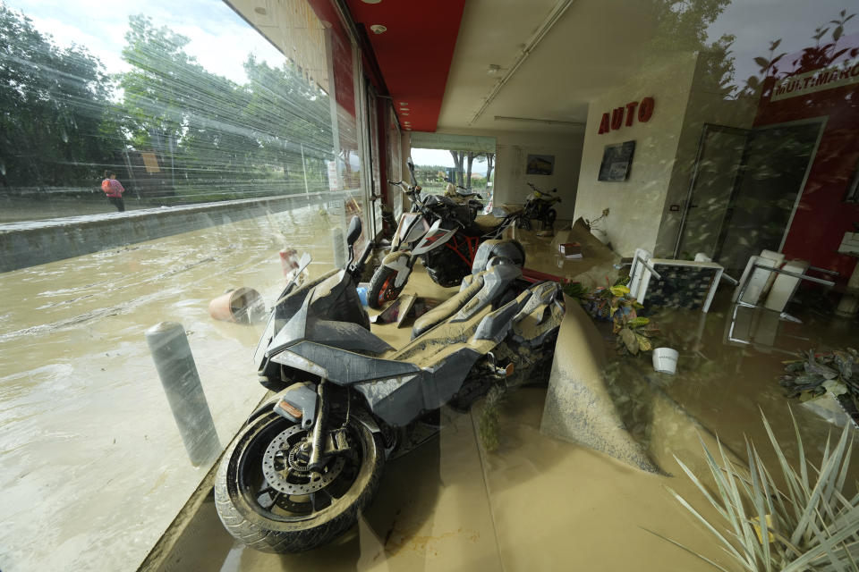 Mud covers motorbikes in a shop in Faenza, Italy, Thursday, May 18, 2023. Exceptional rains Wednesday in a drought-struck region of northern Italy swelled rivers over their banks, killing at least nine people, forcing the evacuation of thousands and prompting officials to warn that Italy needs a national plan to combat climate change-induced flooding. (AP Photo/Luca Bruno)