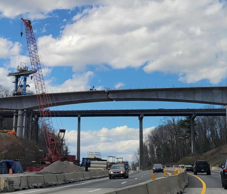 Workers work on the new Blue Ridge Parkway bridge on March 18, with the old bridge in the background.