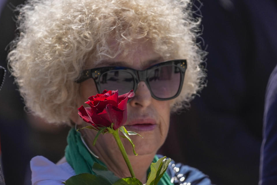 A woman holds a flower during a May Day rally on International Workers Day in Belgrade, Serbia, Monday, May 1, 2023. (AP Photo/Darko Vojinovic)
