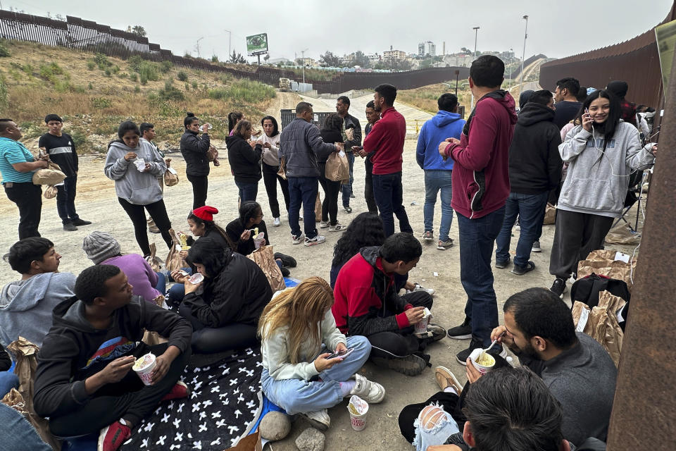 Migrants seeking asylum rest as they wait to be processed after crossing the border Wednesday, June 5, 2024, in San Diego, Calif. President Joe Biden has unveiled plans to enact immediate significant restrictions on migrants seeking asylum at the U.S.-Mexico border as the White House tries to neutralize immigration as a political liability ahead of the November elections. (AP Photo/Eugene Garcia)