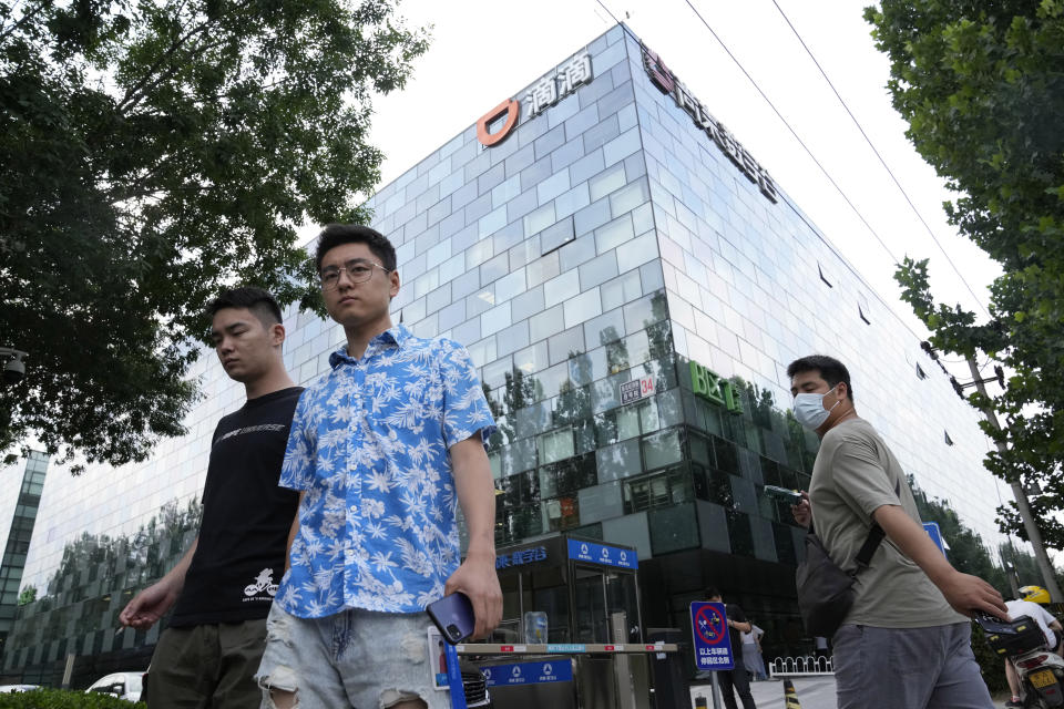 Workers pass by the Didi headquarters in Beijing Friday, July 16, 2021. Didi Global Inc. on Friday, July 30, 2021 denied a report by The Wall Street Journal that the ride-hailing service was considering buying back its U.S.-traded shares after its June market debut was disrupted by Chinese government orders to overhaul data security. (AP Photo/Ng Han Guan)