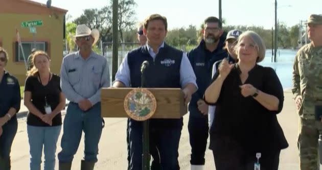 Florida Gov. Ron DeSantis wears branded campaign gear as he speaks Sunday at a press briefing about Hurricane Ian in Arcadia. (Photo: WZVN/Reuters)