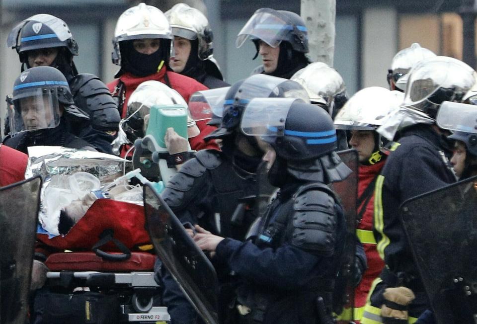 A police officer is taken away on a stretcher after falling ill while policing a demonstration in Paris, Saturday, March 23, 2019. Paris police say the officer suffered a heart incident during yellow vest protests and is in "very serious" condition. The Paris police headquarters said Saturday that the policeman was hospitalized and that the police chief is following the situation closely. (AP Photo/Kamil Zihnioglu)