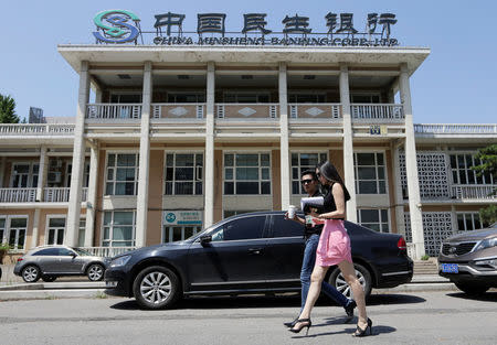 FILE PHOTO: People walk past a branch of China Minsheng Bank in Beijing, June 27, 2013. REUTERS/Jason Lee/File Photo