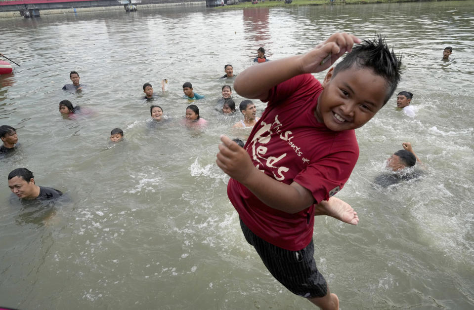 People bathe in the Cisadane River on the first evening of the holy fasting month of Ramadan in Tangerang, Indonesia, Saturday, April 2, 2022. Muslims followed local tradition to wash in the river to symbolically cleanse their soul prior to entering the holiest month in Islamic calendar. (AP Photo/Tatan Syuflana)