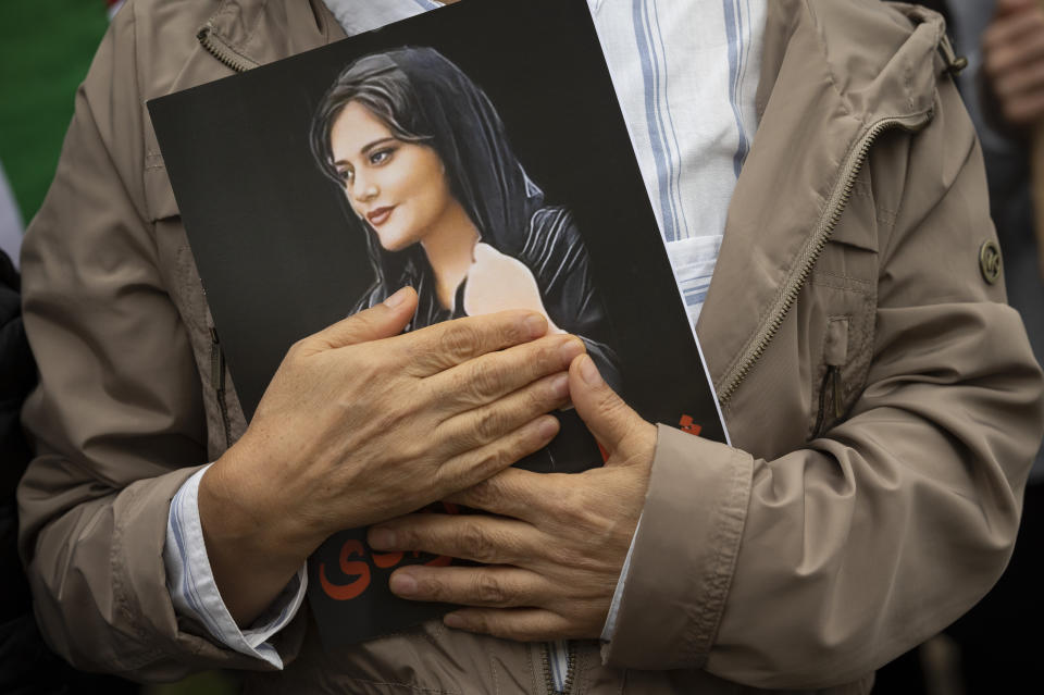 FILE - A portrait of Mahsa Amini is held during a rally calling for regime change in Iran following the death of Amini, a young woman who died after being arrested in Tehran by Iran's notorious "morality police," in Washington, Saturday, Oct. 1, 2022. As anti-government protests roil cities and towns in Iran for a fourth week, sparked by the death of the 22-year-old woman, tens of thousands of Iranians living abroad have marched on the streets of Europe, North America and beyond in support of what many believe to be a watershed moment for their home country. (AP Photo/Cliff Owen, File)