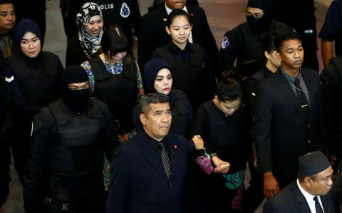 Indonesian Siti Aisyah and Vietnamese Doan Thi Huong, who are on trial for the killing of Kim Jong Nam, the estranged half-brother of North Korea's leader, are escorted as they revisit the Kuala Lumpur International Airport 2 in Sepang - Credit: Reuters