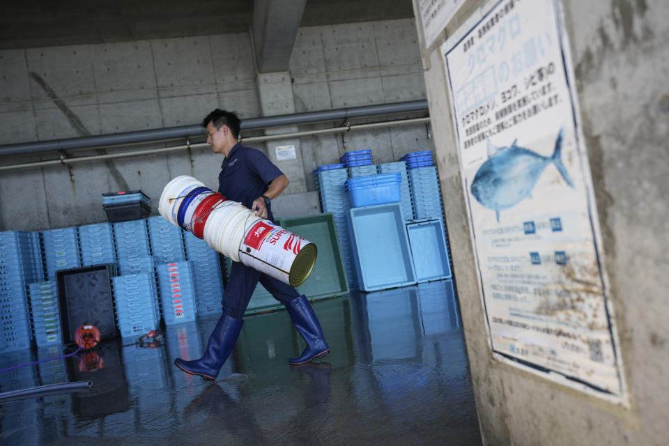 A worker walks at Numanouchi port, Iwaki, northeastern Japan, near the Fukushima Daiichi nuclear power plant, damaged by a massive March 11, 2011, earthquake and tsunami, on Friday, Aug. 25, 2023. Fish auction prices at a port south of the Fukushima Daiichi nuclear power plant Friday somehow dipped amid uncertainty about how consumers may respond a day after release to sea of treated and diluted radioactive wastewater began despite protests at home and in neighboring countries.(AP Photo/Eugene Hoshiko)