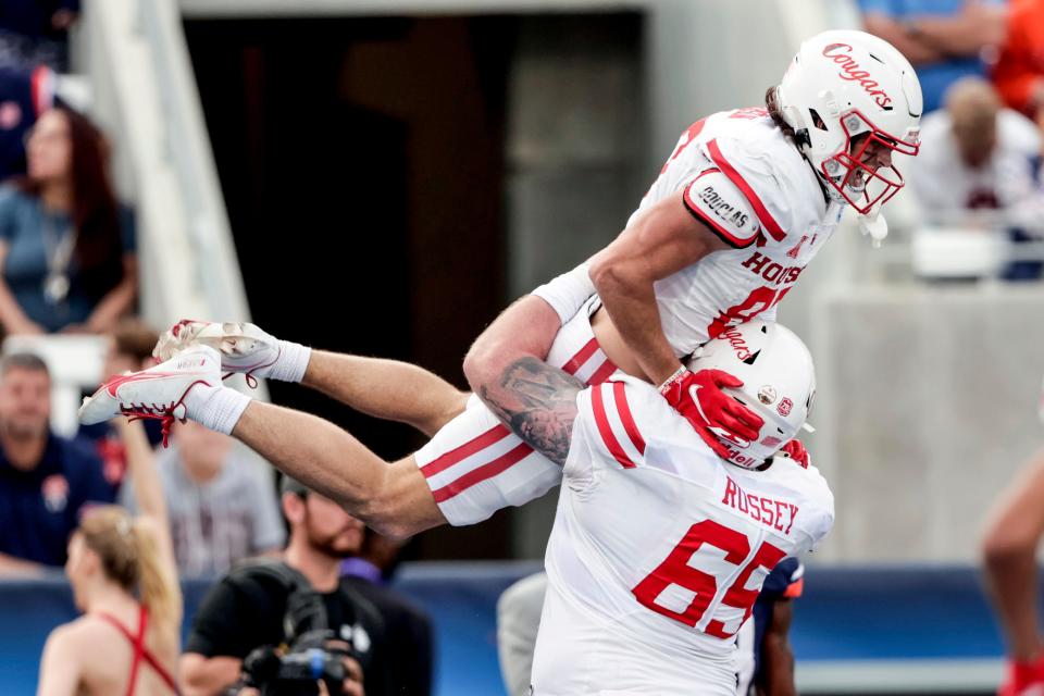 Houston wide receiver Jake Herslow (87) celebrates with offensive lineman Kody Russey (65) after scoring the go ahead touchdown against Auburn during the second half of the Birmingham Bowl NCAA college football game Tuesday, Dec. 28, 2021, in Birmingham, Ala. (AP Photo/Butch Dill)