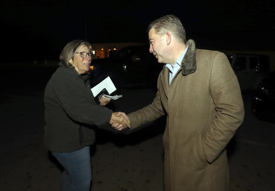 Mike Carey, right, Republican candidate for 15th Congressional District of Ohio, greets voter Sharon Mitchell outside of the Grove City, Ohio, recreation center in Grove City Tuesday, Nov. 2, 2021. Carey and Democratic state Rep. Allison Russo are seeking the Columbus-area 15th Congressional District seat held by Republican Steve Stivers, who resigned to lead the Ohio Chamber of Commerce. (AP Photo/Paul Vernon)