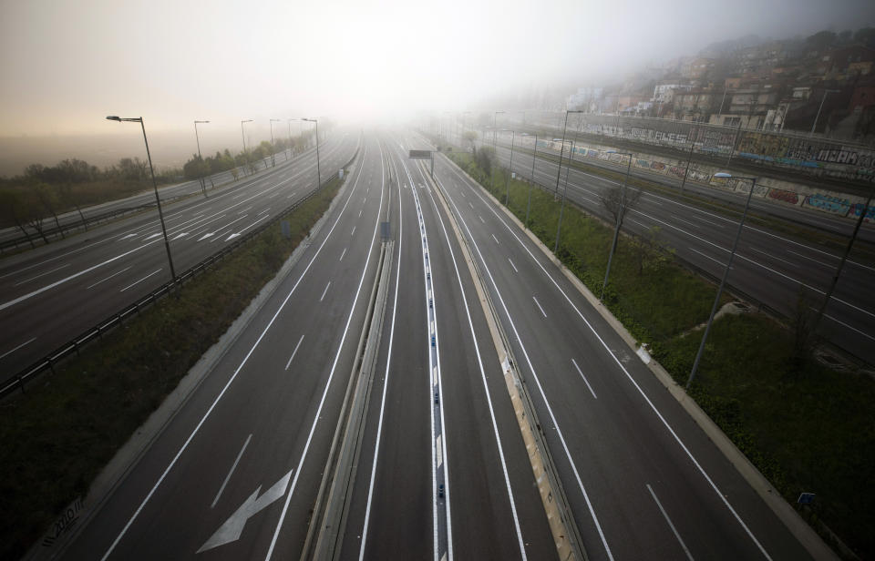 The highway leading to Barcelona is seen empty of cars on Sunday, March 15, 2020. Spain's government announced Saturday that it is placing tight restrictions on movements and closing restaurants and other establishments in the nation of 46 million people as part of a two-week state of emergency to fight the sharp rise in coronavirus infections. For most people, the new coronavirus causes only mild or moderate symptoms. For some, it can cause more severe illness, especially in older adults and people with existing health problems. (AP Photo/Emilio Morenatti)