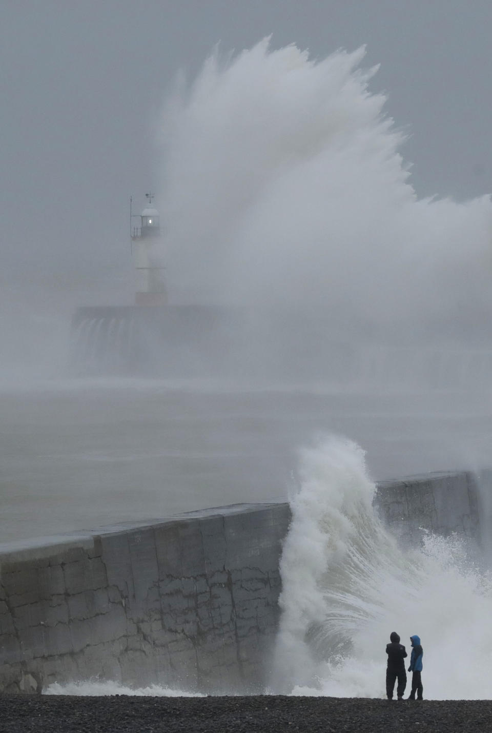 Waves crash over the harbour wall by a lighthouse as Storm Ciara hits Newhaven, on the south coast of England, Sunday, Feb. 9, 2020. Trains, flights and ferries have been cancelled and weather warnings issued across the United Kingdom and in northern Europe as the storm with winds expected to reach hurricane levels batters the region. (AP Photo/Matt Dunham)