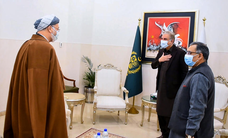 In this photo provided by Pakistan's Ministry of Foreign Affairs, Pakistani Foreign Minister Shah Mahmood Qureshi, second from right, greets Karim Khalili, left, an influential Afghan Shiite leader, upon his arrival at ministry for a meeting, in Islamabad, Pakistan, Tuesday, Jan. 12, 2021. Khalili is visiting Pakistan where members of the minority sect are still reeling from the brutal killing of 11 Shiite coal miners, nine of whom were Afghan immigrants, earlier this month. (Ministry of Foreign Ministry via AP)