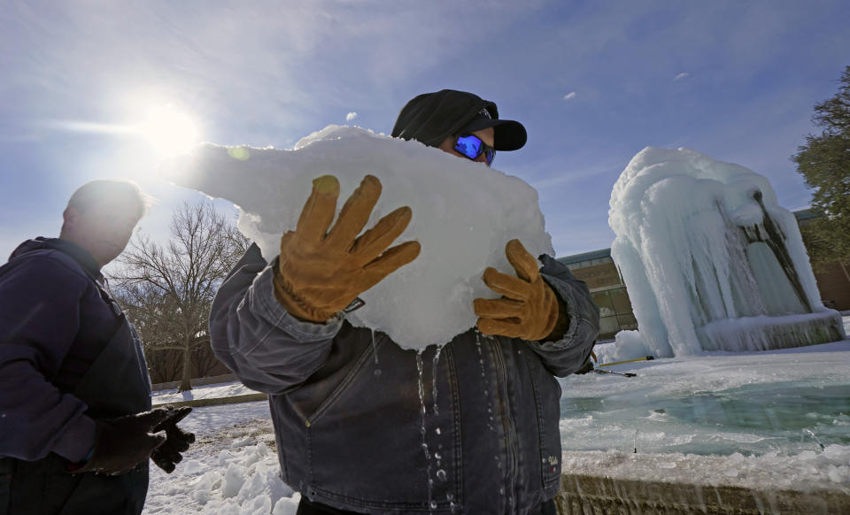 City of Richardson workers clear ice from a frozen fountain Tuesday, Feb. 16, 2021, in Richardson, Texas. Temperatures dropped into the single digits as snow shut down air travel and grocery stores.(AP Photo/LM Otero)