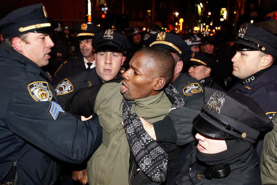 Police make an arrest as protesters rallying against a grand jury's decision not to indict the police officer involved in the death of Eric Garner march through Midtown in the early morning hours of Friday, Dec. 5, 2014, in New York. (AP Photo/Jason DeCrow)