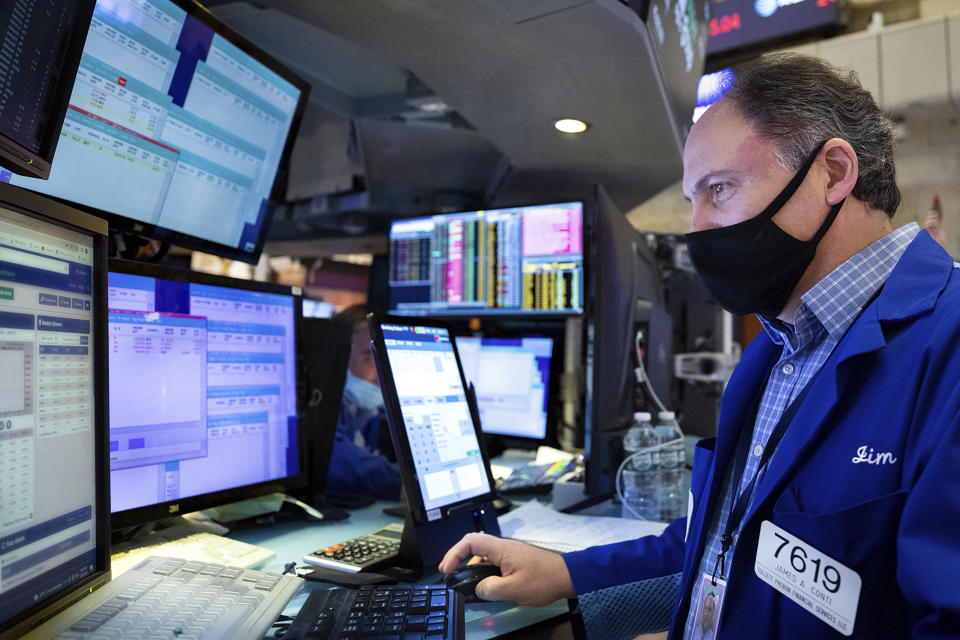 In this photo provided by the New York Stock Exchange, James Conti works at his post on the floor, Friday, Jan. 28, 2022. Stocks rose in afternoon trading on Wall Street Friday, potentially trimming losses for some of the major indexes this week. (Allie Joseph/New York Stock Exchange via AP)