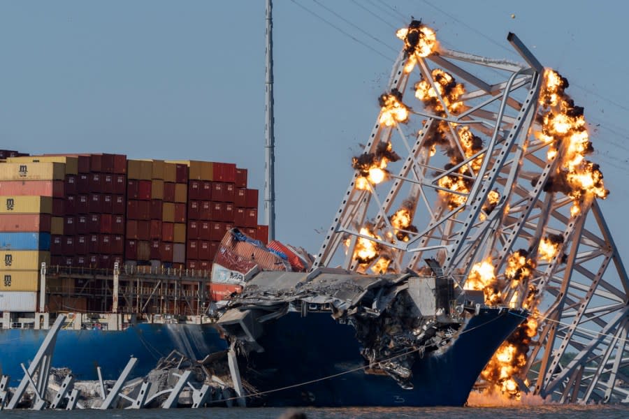 Explosive charges are detonated to bring down sections of the collapsed Francis Scott Key Bridge resting on the container ship Dali on Monday, May 13, 2024, in Baltimore. (AP Photo/Mark Schiefelbein)