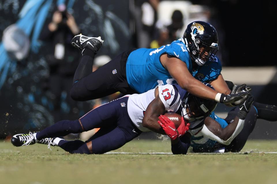 Jacksonville Jaguars defensive tackle Corey Peters (98) tackles Houston Texans wide receiver Brandin Cooks (13) during the fourth quarter of an NFL football game Sunday, Oct. 9, 2022 at TIAA Bank Field in Jacksonville. The Houston Texans defeated the Jacksonville Jaguars 13-6. [Corey Perrine/Florida Times-Union]