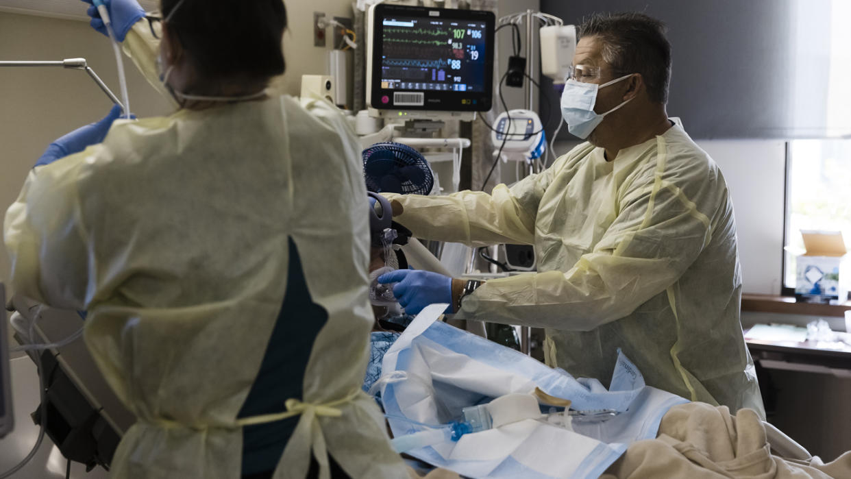 Healthcare workers treat a patient inside a negative pressure room in the Covid-19 intensive care unit (ICU) at Freeman Hospital West in Joplin, Missouri, U.S., on Tuesday, Aug. 3, 2021. (Angus Mordant/Bloomberg via Getty Images)