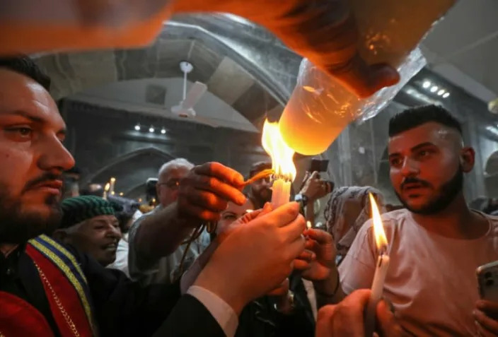 Iraqi Orthodox Christians share the flame of the "Holy Fire" brought from Jerusalem (AFP/SAFIN HAMED)