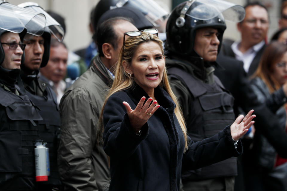 Bolivia's interim President Jeanine Anez speaks to police in front of the presidential palace, in La Paz, Bolivia, Wednesday, Nov. 13, 2019. The new interim president faces the challenge of stabilizing the nation and organizing national elections within three months at a time of political disputes that pushed former President Evo Morales to fly off to self-exile in Mexico after 14 years in power. (AP Photo/Juan Karita)