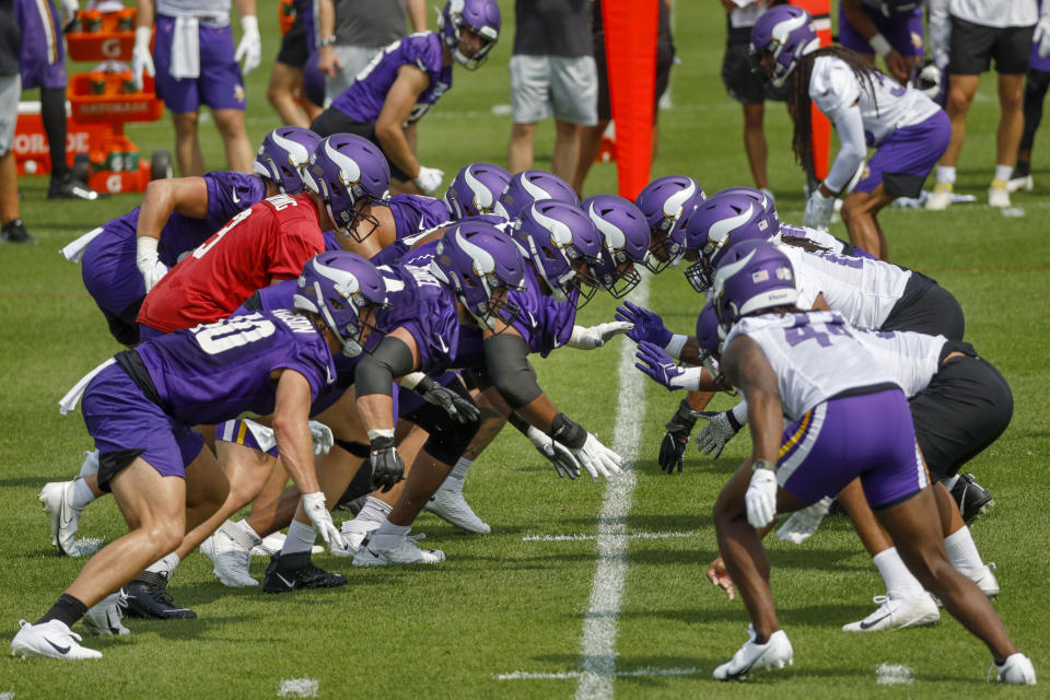 Led by quarterback Jake Browning, in red,, the Minnesota Vikings offense practices against the defense during NFL football training camp Wednesday, July 28, 2021, in Eagan, Minn. (AP Photo/Bruce Kluckhohn)