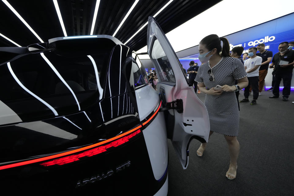 A woman attends a preview of the Apollo RT6, a fully electric vehicle with an "optional" steering wheel that can be removed or installed when required, Wednesday, July 20, 2022, in Beijing. Chinese search engine and artificial intelligence firm Baidu on Thursday, July 21 unveiled its latest electric autonomous driving vehicle that it says will be soon be part of its robotaxi fleet, as China pushes forward with its autonomous driving ambitions. (AP Photo/Ng Han Guan)