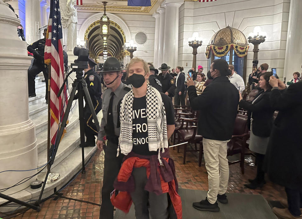 Police arrest some of about 200 people taken into custody on Monday, February 5, 2024, in the Rotunda of the State Capitol in Harrisburg, Pennsylvania. The arrests shut down a demonstration against the state Treasury Department's investment of about $56 million in Israel bonds. The protest was organized by Jewish Voice for Peace, the Philly Palestine Coalition and the Pennsylvania Council on American-Islamic Relations. (AP Photo/Mark Scolforo)