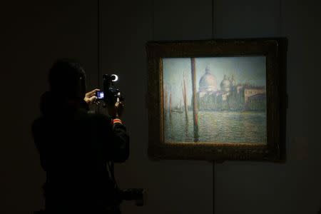 A cameraman films in front of "Le Grand Canal", painted by Claude Monet, at Sotheby's preview in Hong Kong January 9, 2015. The art piece is expected to fetch between 20 and 30 million pounds at the upcoming Impressionist & Modern Art Evening Sale in London on February 3, 2015, according to Sotheby's. REUTERS/Bobby Yip