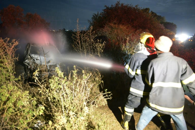 Firefighters put out a fire on a burning car which was involved in an accident with an oil tanker near the town of Naivasha, Kenya, on December 11, 2016