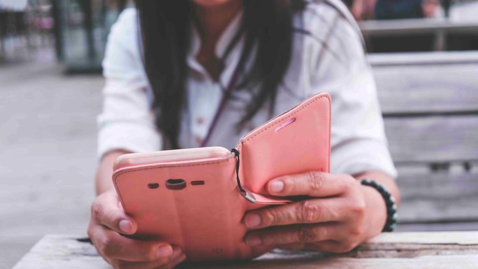 Stock image of a woman withy long black hair looking at her phone