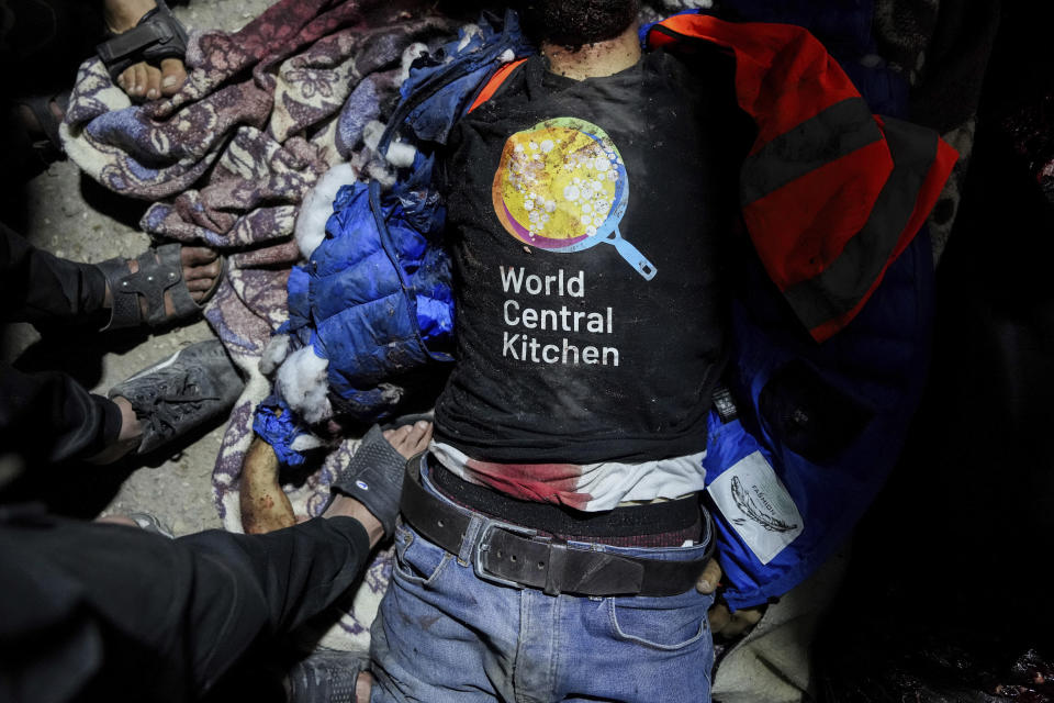 El cuerpo de una persona con una camiseta de World Central Kitchen se ve en el suelo en el hospital Al Aqsa en Deir al-Balah, Franja de Gaza, el lunes 1 de abril de 2024. Un aparente ataque israelí mató a seis trabajadores internacionales de la organización benéfica World Central Kitchen y a su conductor palestino, según indicó el grupo de ayuda el martes, horas después de llevar un nuevo cargamento de comida por mar al norte de Gaza, una zona aislada y llevada al borde de la hambruna por la ofensiva israelí. (AP Foto/Abdel Kareem Hana)