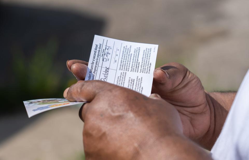 Thomas Miller, 53, of Detroit, looks over his vaccination card after receiving a Moderna COVID-19 vaccine on Wednesday, April 28, 2021.