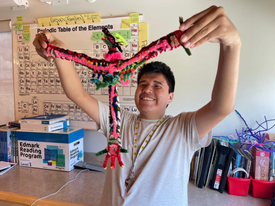 Kieron Mackenzie, 18, is a student at K'alemi Dene School in Ndilǫ, N.W.T. The dragons he makes out of pipe cleaners is now part of a mobile art exhibit in Yellowknife. (Loren McGinnis/CBC - image credit)