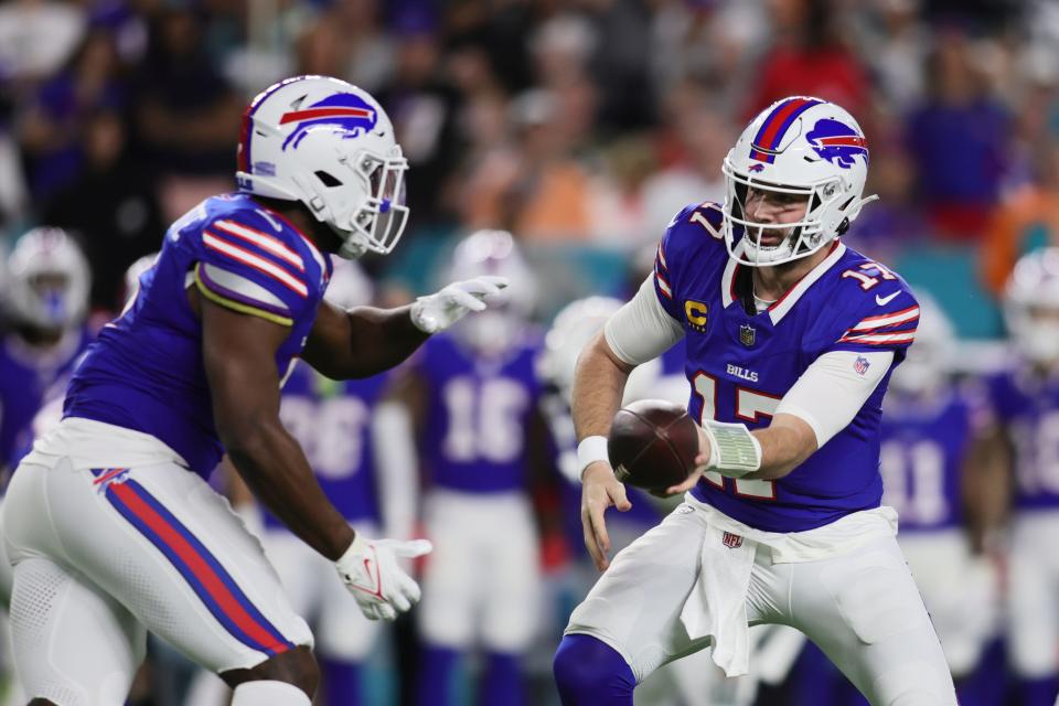 Buffalo Bills quarterback Josh Allen (17) gives the football to running back Leonard Fournette (5) against the Miami Dolphins during the first quarter at Hard Rock Stadium.