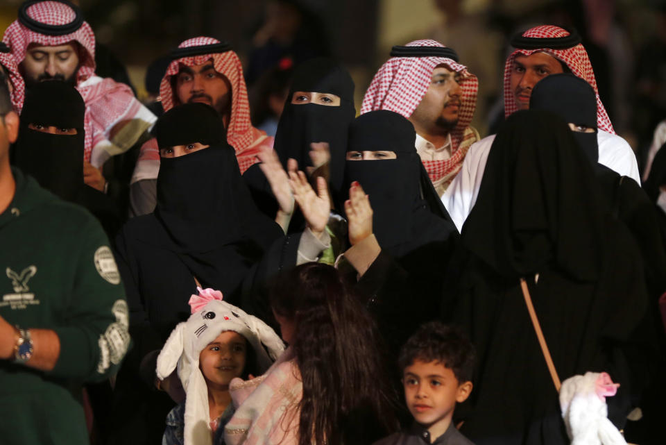 In this Dec. 13, 2019 photo, visitors watch an acrobat player at the Diriyah Oasis amusement park in Diriyah on the outskirts of Riyadh, Saudi Arabia. Hollywood actors, models and social media mavens were invited to Saudi Arabia over the weekend to promote a three-day-long musical festival for young Saudis that took place in the capital, Riyadh. The efforts are aimed at boosting the economy while polishing the country's image abroad and appealing to the young. It's a pivot from just three years ago, when religious police would storm restaurants playing music and harass women in malls for showing their face or wearing red nail polish. (AP Photo/Amr Nabil)