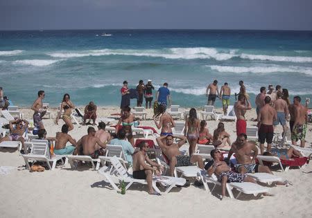 Spring breakers lay on the beach in Cancun March 14, 2015. REUTERS/Victor Ruiz Garcia