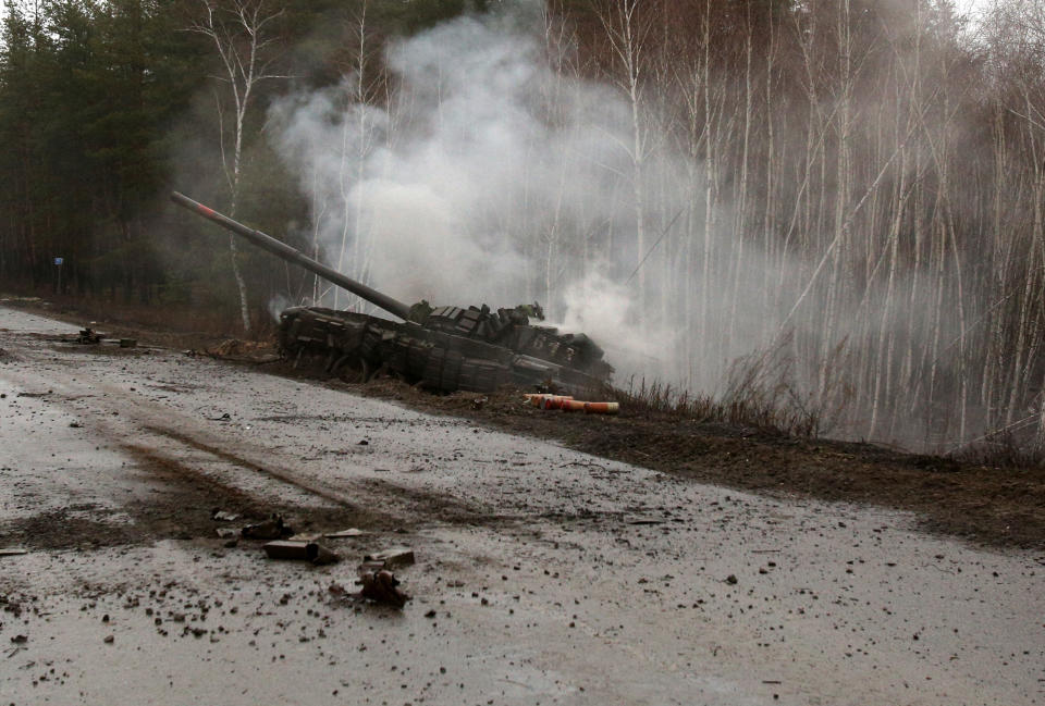 Smoke rises from a Russian tank destroyed by the Ukrainian forces on the side of a road in Lugansk region on February 26, 2022. - Russia on February 26 ordered its troops to advance in Ukraine 