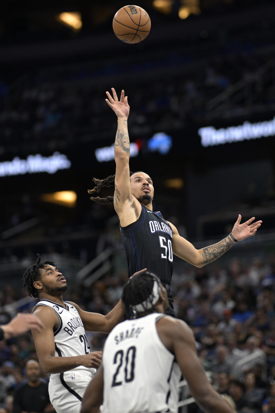 Orlando Magic guard Cole Anthony (50) goes up to shoot as Brooklyn Nets guard Cam Thomas (24) and center Day'Ron Sharpe (20) watch during the first half of an NBA basketball game, Sunday, March 26, 2023, in Orlando, Fla. (AP Photo/Phelan M. Ebenhack)