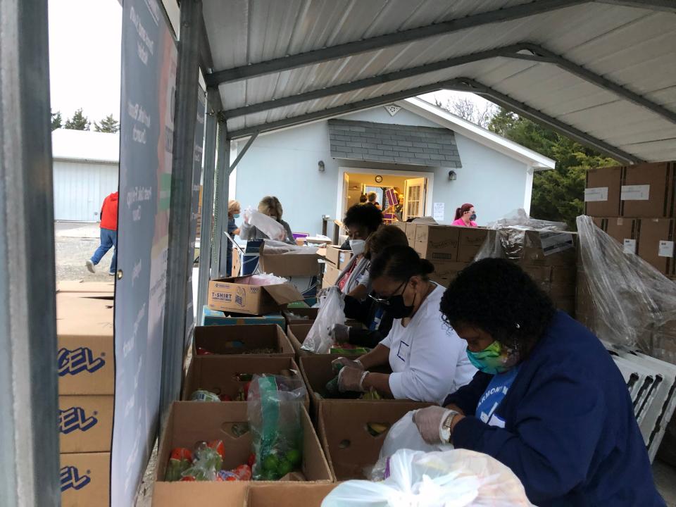 Ladies work to sort the food provided for the multi-organizational Thanksgiving Dinner giveaway in this 2020 photo.