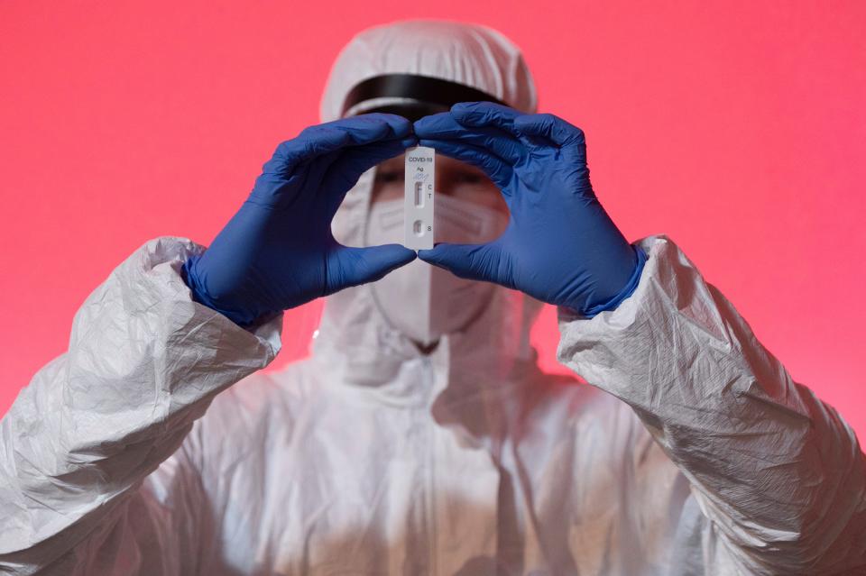 An employee at a COVID-19 test center in Wilsdruff, Germany, shows a rapid test on Friday.