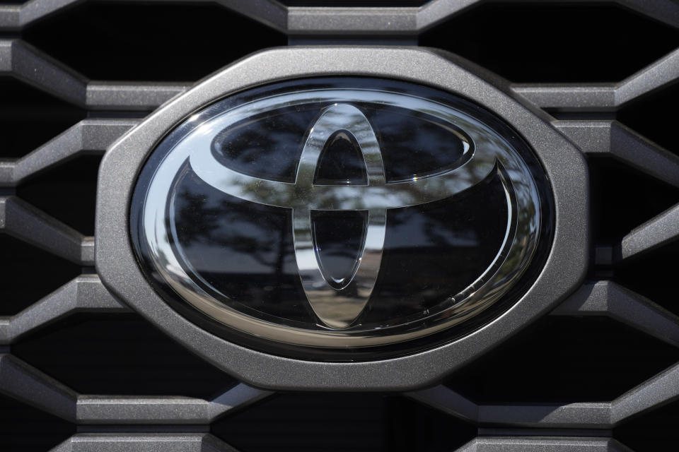 FILE - The company logo shines off the grille of a 2021 Tacoma pickup truck on display in the Toyota exhibit at the Denver auto show Friday, Sept. 17, 2021, at Elitch's Gardens in downtown Denver. Japan’s top automaker Toyota reported Thursday, Nov. 4, 2021, a 33% jump in second fiscal quarter profit, as it raised its full year forecast, despite supply chain woes related to the coronavirus pandemic. (AP Photo/David Zalubowski, File)